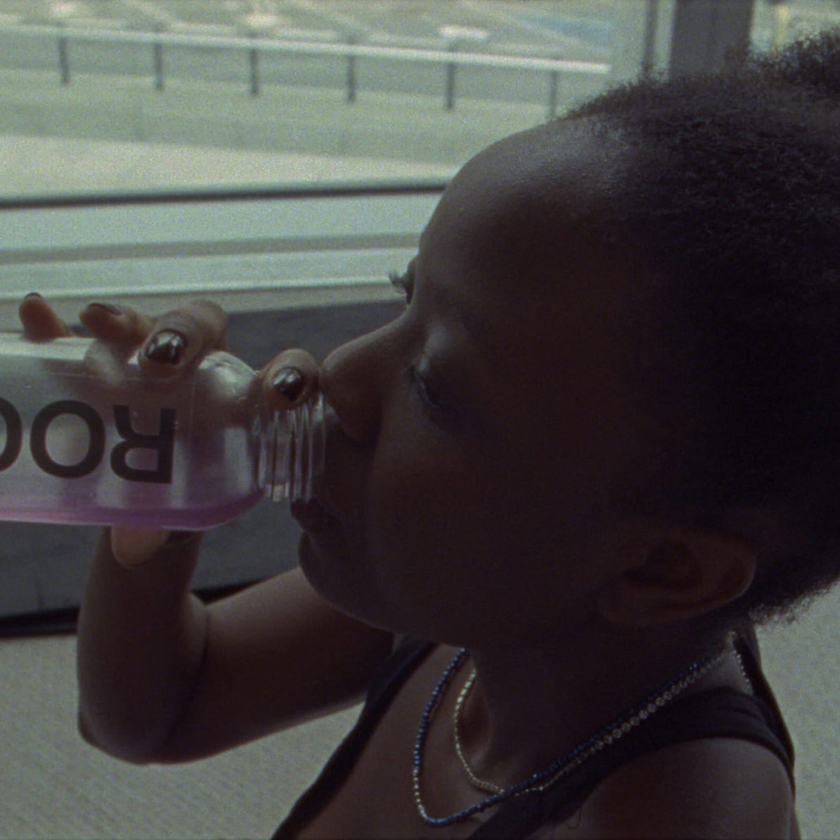 Women holding a pink object with 'Rocque' branding in front of a window.