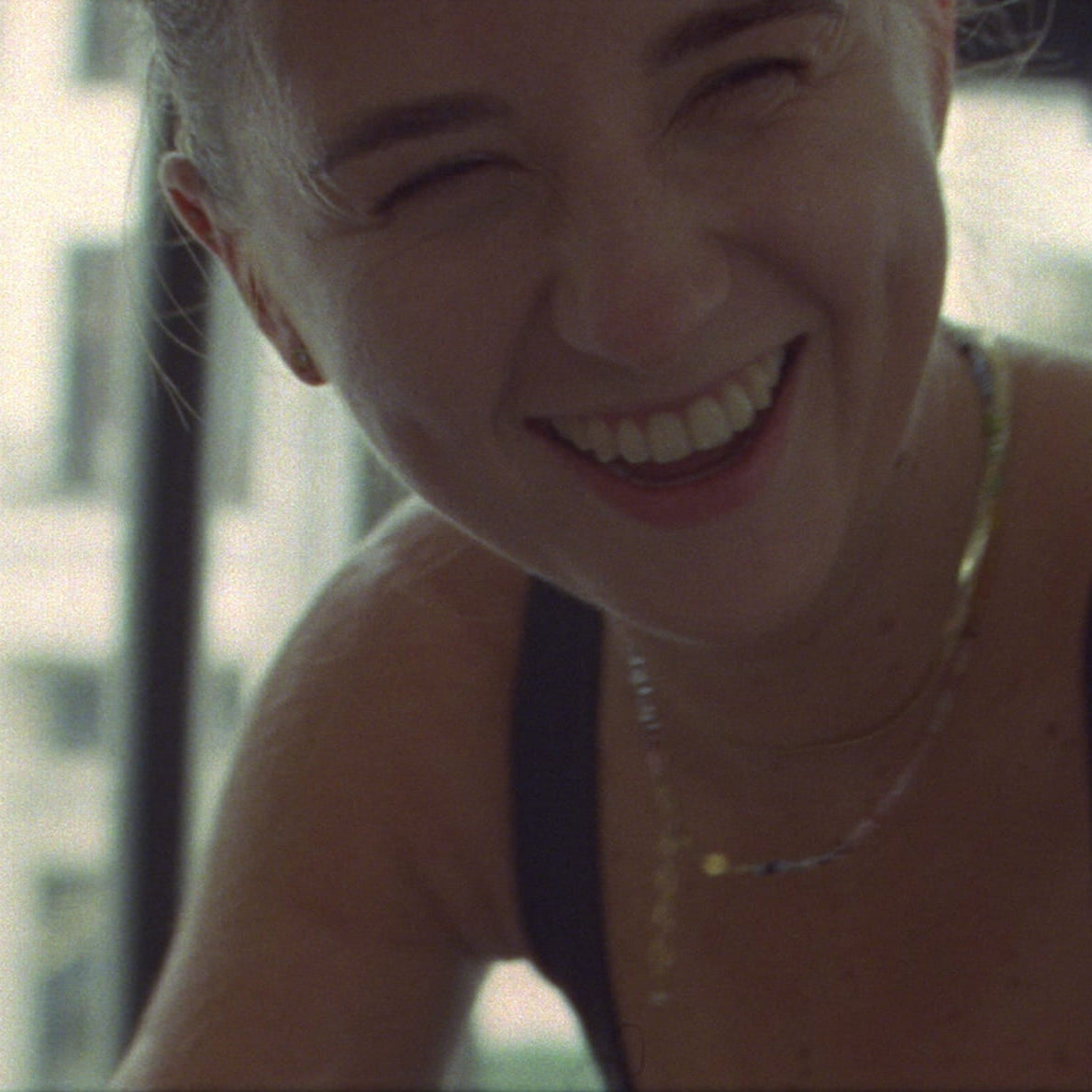 Woman smiling with a blurred cityscape in the background